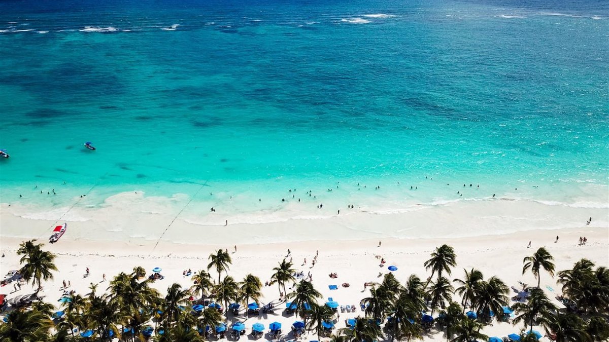 Aerial view of Las Palmas beach in Tulum with wide white sand and palm trees along turquoise water