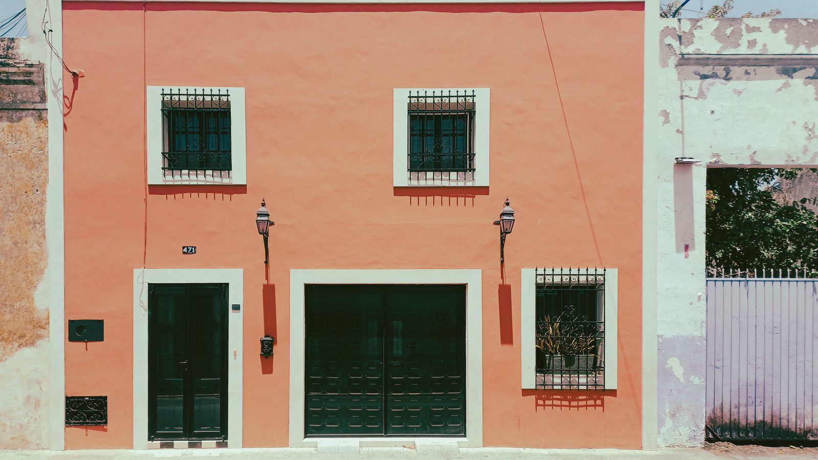 Brightly painted colonial house facades on a street in central M&eacute;rida