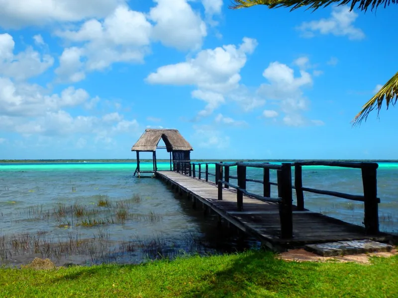 Wooden jetty with a palapa over the turquoise Bacalar lagoon