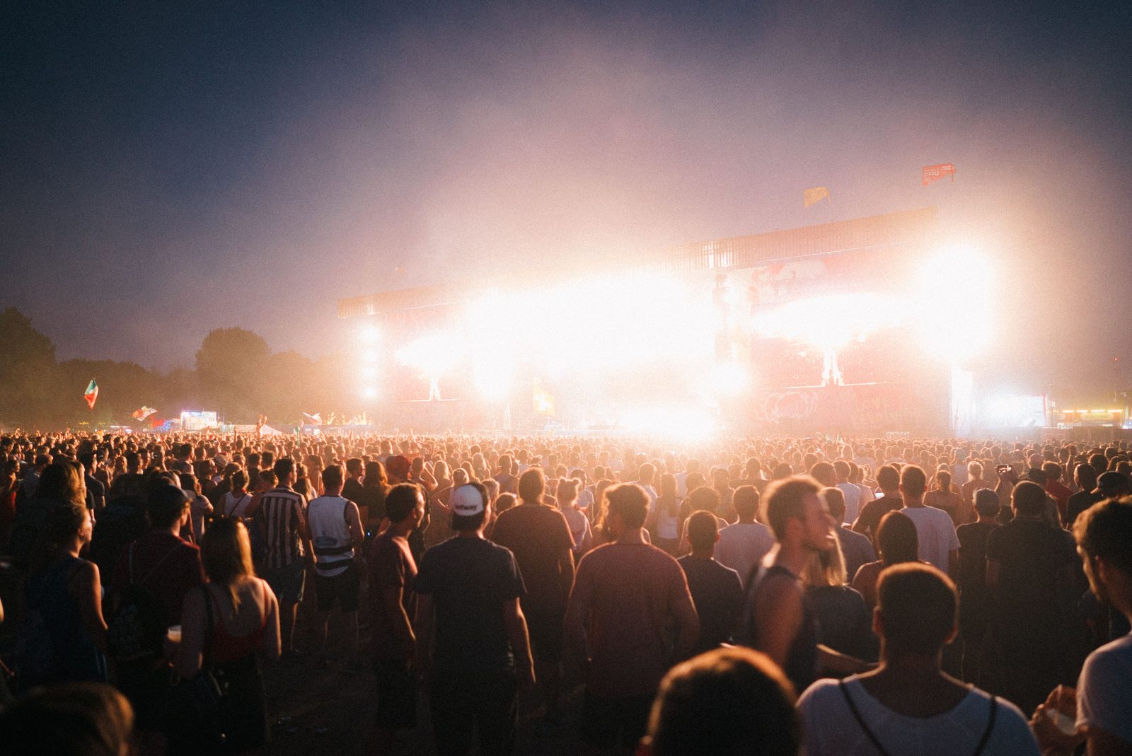 Menge mit erhobenen Händen bei einem Open-Air-Musikfestival in der Dämmerung