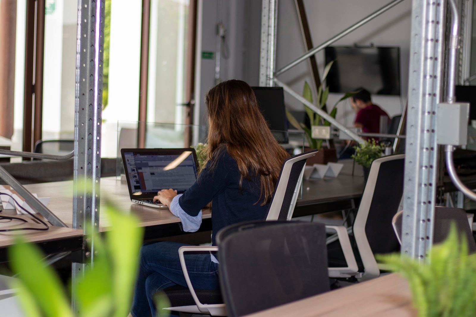 Digital nomad working on a laptop in a bright modern coworking space in Tulum