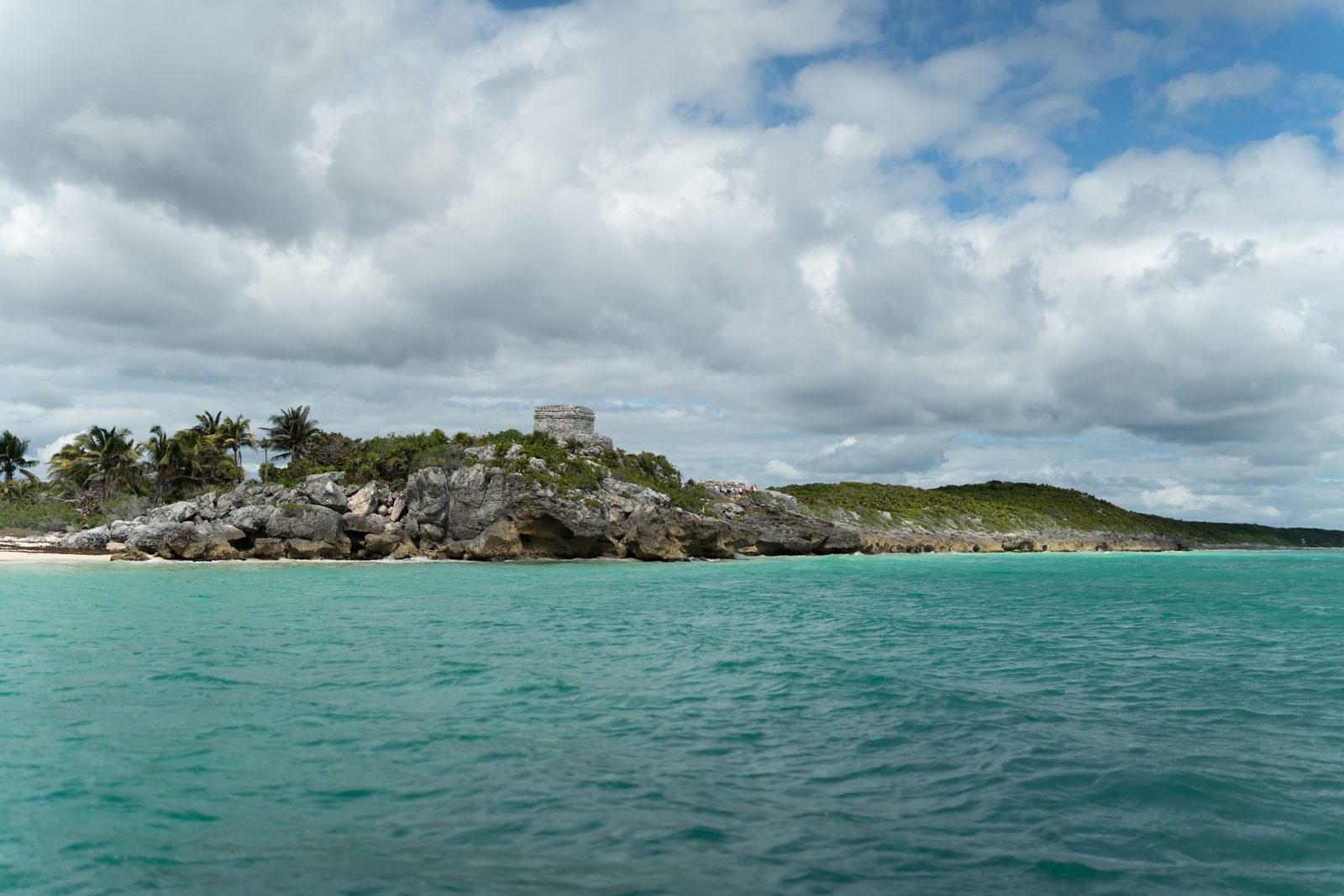 Aguas turquesa y costa rocosa en la playa bajo las ruinas de Tulum