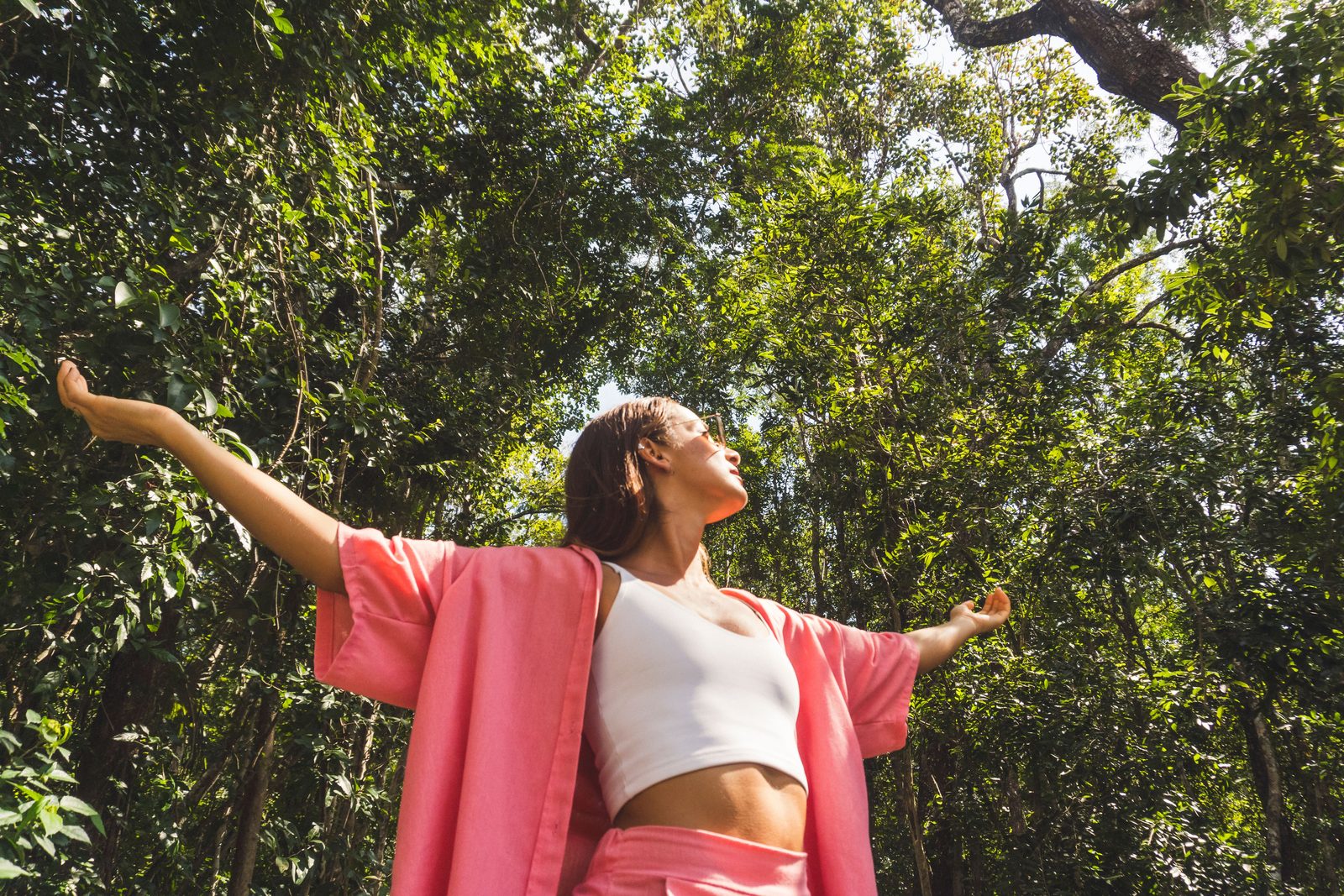 Woman embracing tropical jungle nature at a Tulum wellness retreat